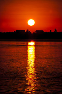 sunset behind island over ocean 