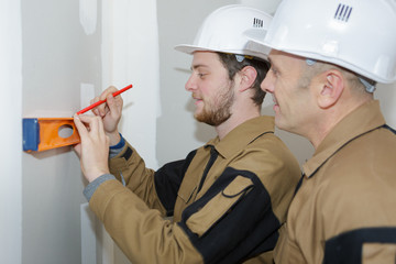 teacher helping students training to be builders