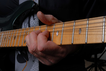 Fototapeta na wymiar neck of guitar with arm and hand playing the strings 