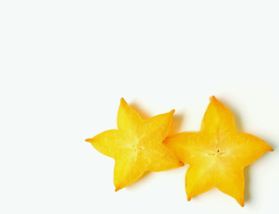 Fototapeta premium Closed up pair of vibrant yellow sliced ripe Star Fruits on white background, with free space for design and text 
