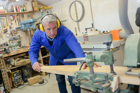 Senior woodworker using machinery