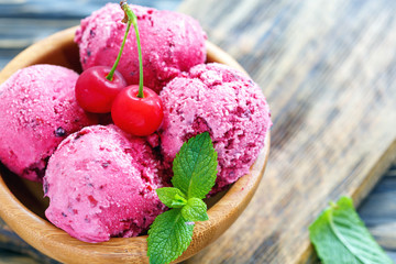 Refreshing cherry ice cream in a wooden bowl.