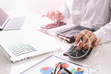 businessman hand working with finances about cost and calculate  and latop with mobile phone on withe desk in modern office