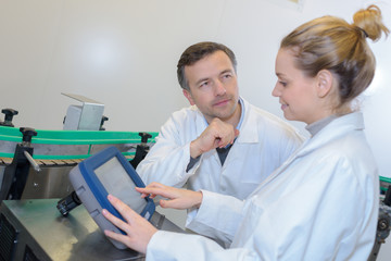 Obraz premium Workers in white jackets looking at tablet screen