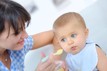 Lady spoon feeding baby