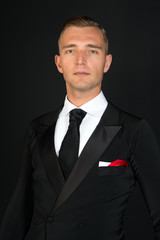 Confident attractive young man in tuxedo