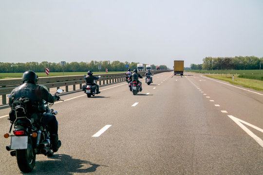 A Group Of Bikers Are Driving Along The Highway