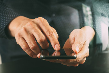 close up of businessman hand working with mobile phone in modern office
