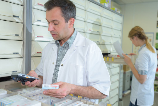 Pharmacist checking medication on electronic device