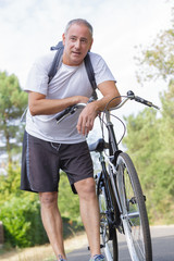 Fototapeta premium Portrait of middle aged man and his bicycle