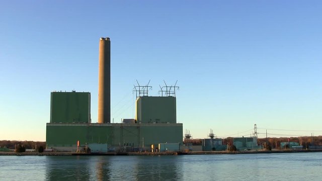 Power plant on cape cod canal with no emissions or pollution from smoke stack against blue sky with sounds of birds and seagulls in early spring morning.