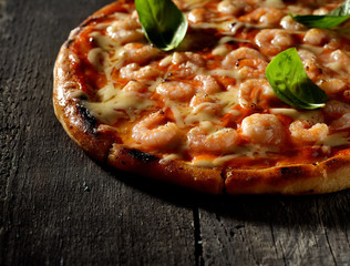 Pizza with shrimps on a wooden background