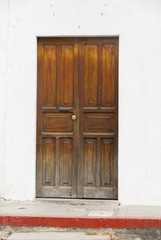 Window and wooden door in colonial house of La Antigua Guatemala, Central America.