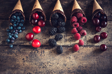 Naklejka na ściany i meble Fresh berries in the ice cream cones