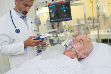 Doctor monitoring patient wearing oxygen mask