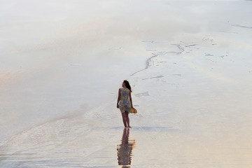 Woman relaxing at the beach with arms open enjoying her freedom