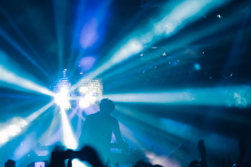 Fototapeta na wymiar Deejay on a stage with disco ball with rays background