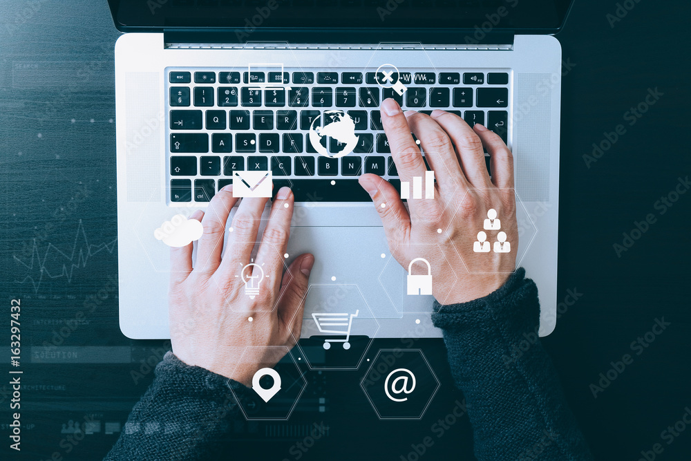 Poster top view of businessman typing keyboard with laptop computer on wooden desk in modern office with virtual reality icon diagram