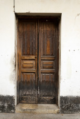 Fototapeta na wymiar Window and wooden door in colonial house of La Antigua Guatemala, Central America.