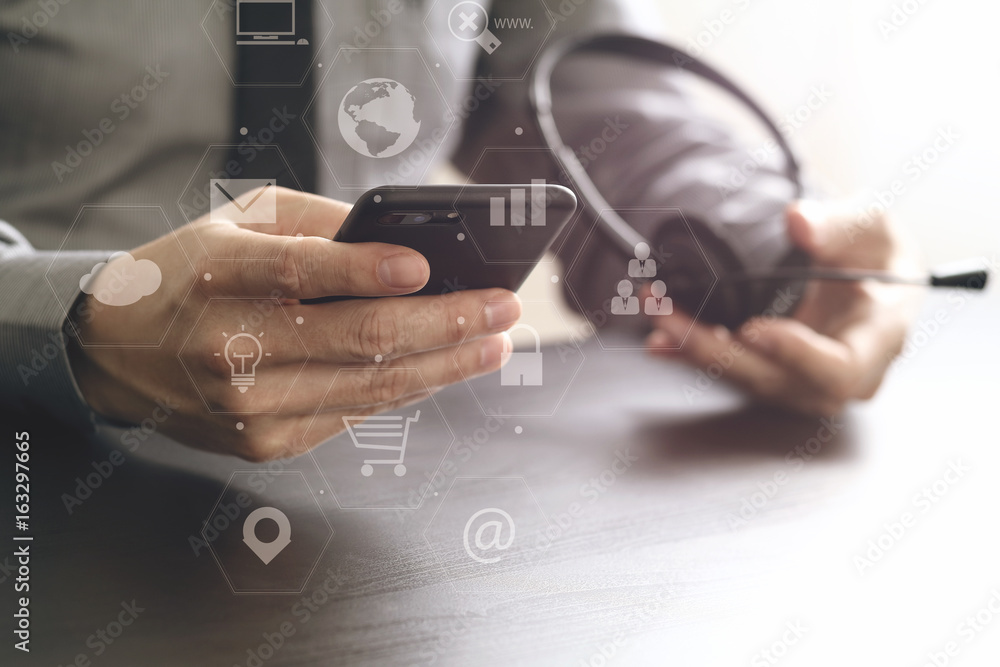 Poster businessman using voip headset with mobile phone and concept communication call center on wooden des