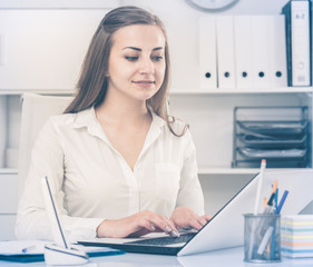 Office female worker is working on laptop