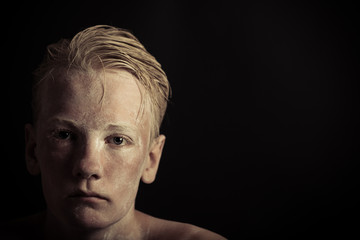 Strange sad boy with blond hair and no shirt