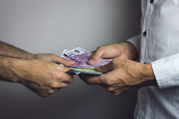Businessman gives money to another