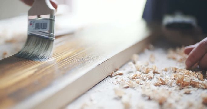 Close-up of Wood painting with a brush with the brown color