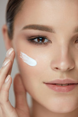 Beauty Cosmetics. Sexy Girl Face With Cosmetic Cream On Skin
