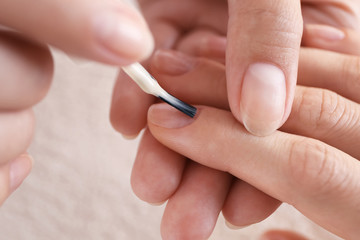 Master applying nail polish on woman fingernails