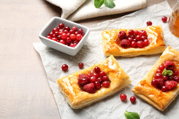 Food paper with delicious pastries on wooden table
