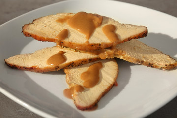 Delicious sliced turkey poured with sauce on plate