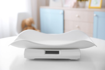 Digital baby scales on table in light room