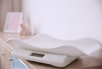 Digital baby scales on table in light room