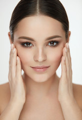 Beauty Woman Face. Girl With Natural Makeup Touching Facial Skin