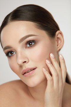 Cosmetic Face Care. Young Woman Caressing Facial Skin