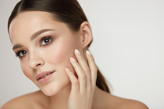 Cosmetic Face Care. Young Woman Caressing Facial Skin