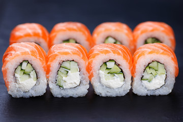 Fototapety  Smaczne i świeże rolki sushi philadelphia podawane na czarnym łupku, z bliska. Pyszne japońskie owoce morza?