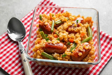 Composition with tasty lentil porridge, sausages and vegetables on kitchen table, closeup