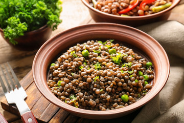 Composition with tasty lentil porridge on wooden table, closeup
