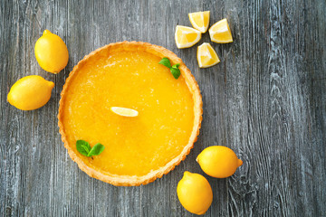 Lemon tart with mint on wooden table
