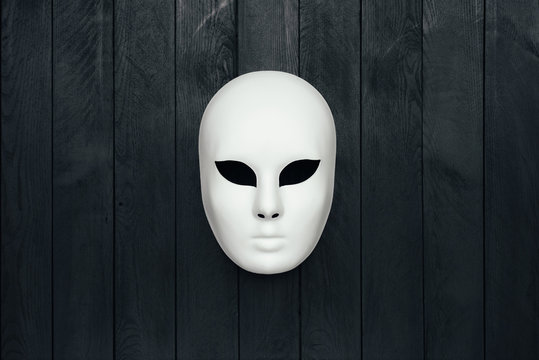 Masquerade mask on black wall. Copy space.