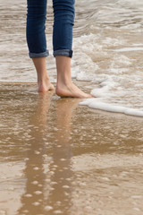 Solitary person walking - wading in incoming waves