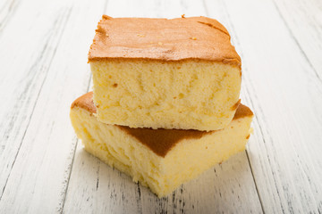 side view two sponge cakes on white wood background