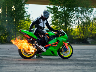 Obraz na płótnie Canvas Мотоцикл показывает трюки с огнем