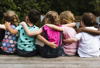 Group of kindergarten kids friends arm around sitting together