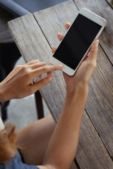 Top view : young woman sitting at a table with a coffee using mobile phone.