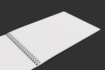 Open blank white notebook with metal spiral bound on black background