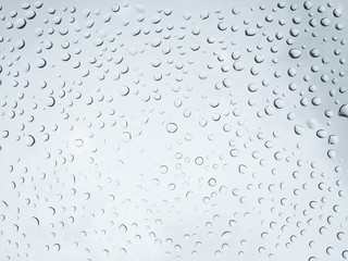 Drop of rain on glass mirror. Water drop on gray abstract background.