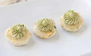 Mini cauliflower casseroles with avocado cream on a white plate
